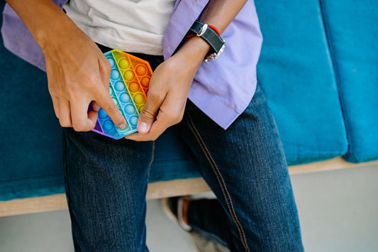 Fidget Clothing vs Traditional Fidget Toys: Why Wearing Your Calm Works Better